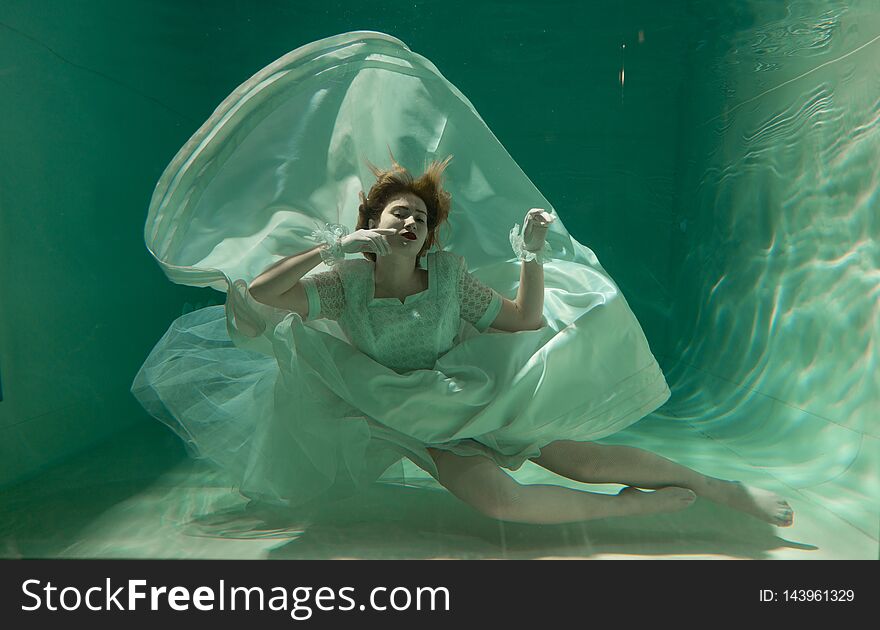 Hot Slim Woman Posing Under water in beautiful clothes alone in the deep