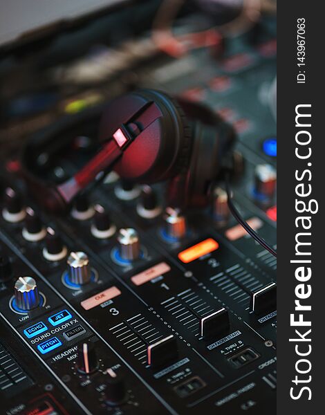 DJ equipment. Player and mixing console with headphones. Night club, music and DJ performance. Nightlife, learning concept. Soft focus and beautiful bokeh.