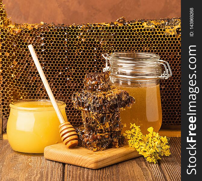 Fresh fragrant honey in a glass jar on a wooden background on the table. Different types of bee honey. Natural products.