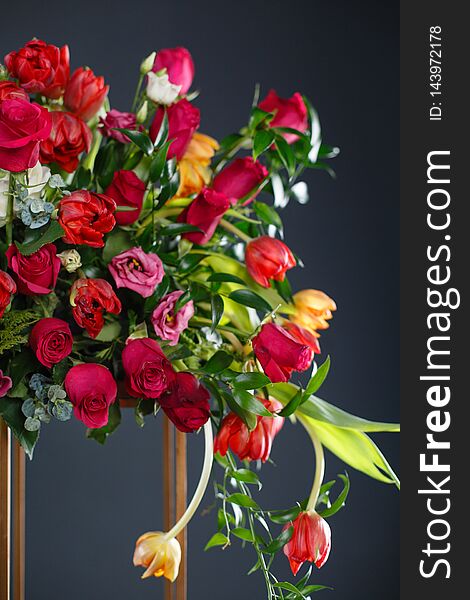 Beautiful flowers on black background. Elegant wedding ceremony. Black room decorated with red flowers