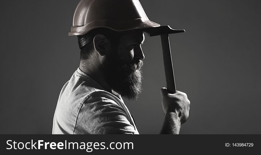 Hammer hammering. Builder in helmet, hammer, handyman, builders in hardhat. Handyman services. industry, builder man. Bearded man worker with beard, building helmet, hard hat. Black and white