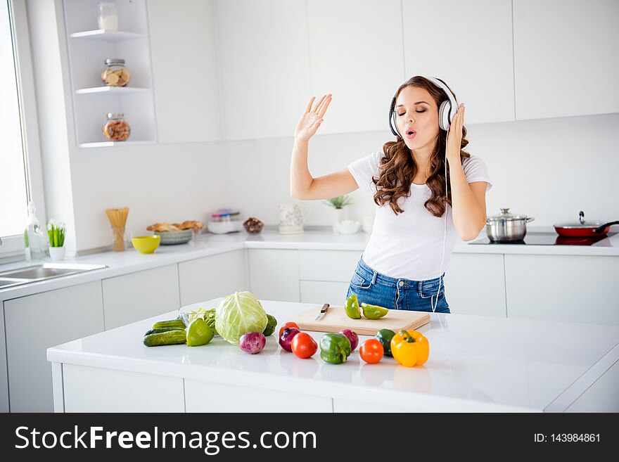 Portrait of her she nice attractive charming lovely cheerful positive mood wavy-haired girl making house work organic ripe mix vegs having fun time in light white interior room.