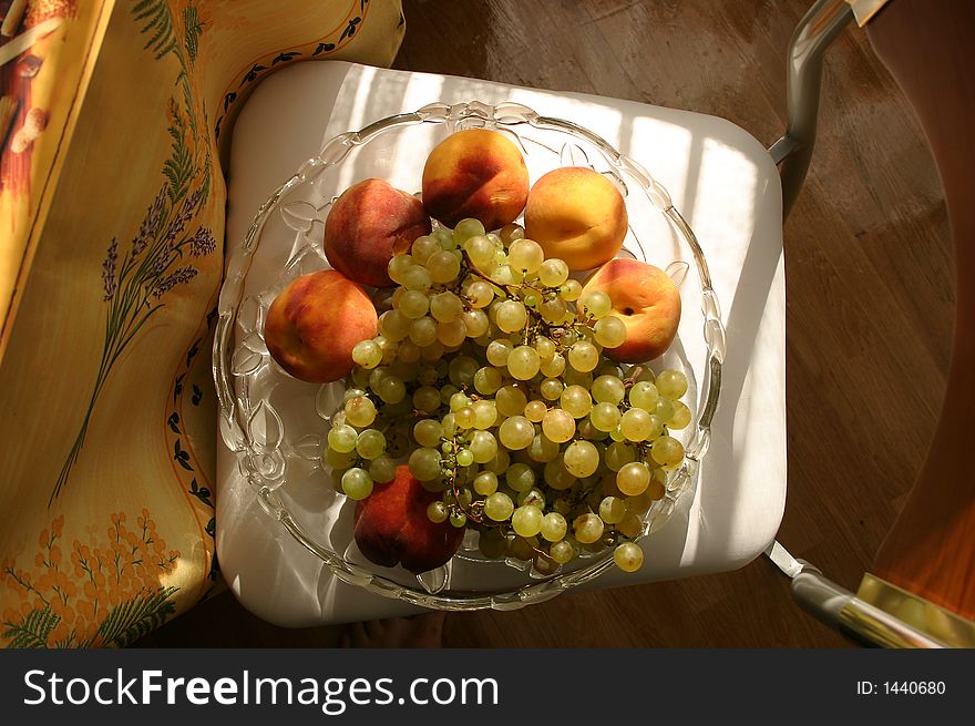 Still life. Peach and grape on the chair