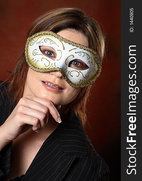 Brunette model with a masquerade mask on her face. Brunette model with a masquerade mask on her face