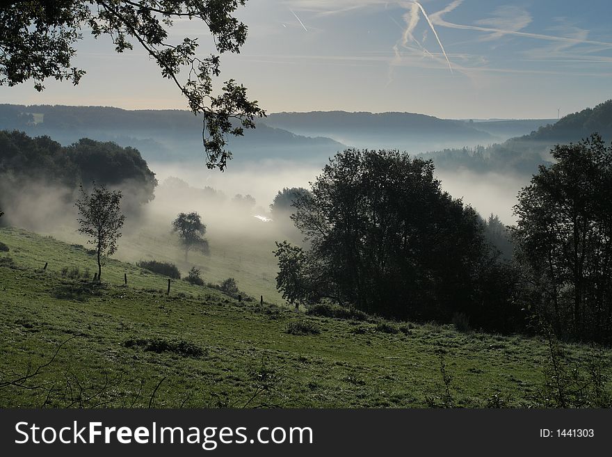 Hills and valleys on a misty fall morning in the Palatine region of Germany. Hills and valleys on a misty fall morning in the Palatine region of Germany.