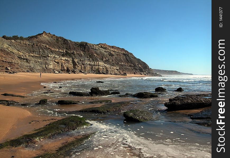 Sand beach. Stones in the ocean water. Sand beach. Stones in the ocean water.