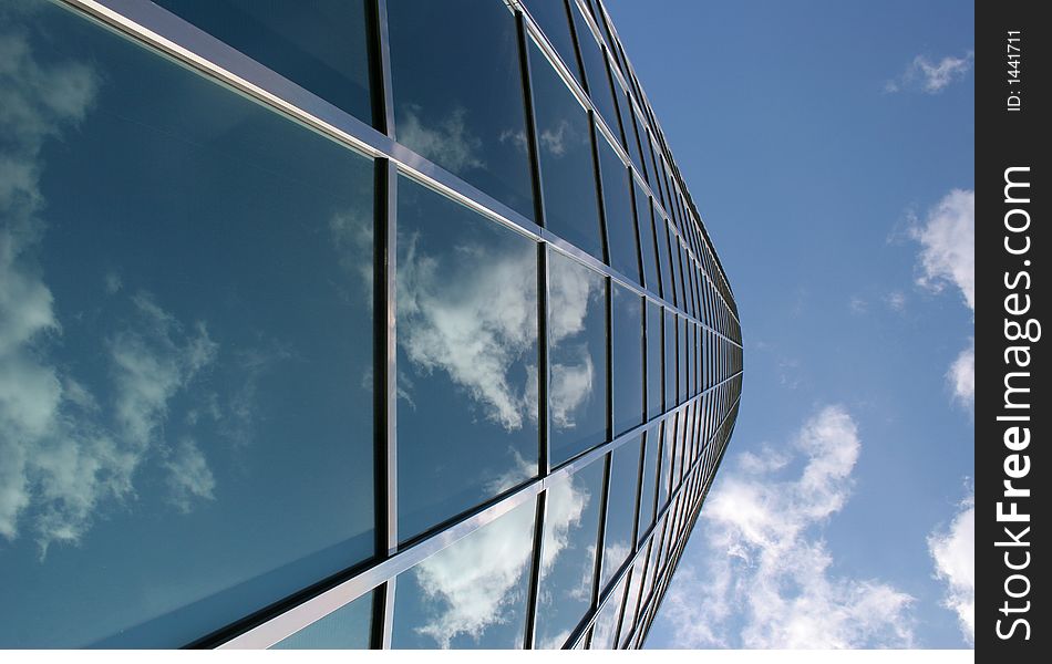 Modern office building with reflections of blue sky and clouds. Modern office building with reflections of blue sky and clouds