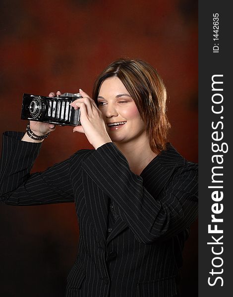 Model holding old camera in front of red background. Model holding old camera in front of red background