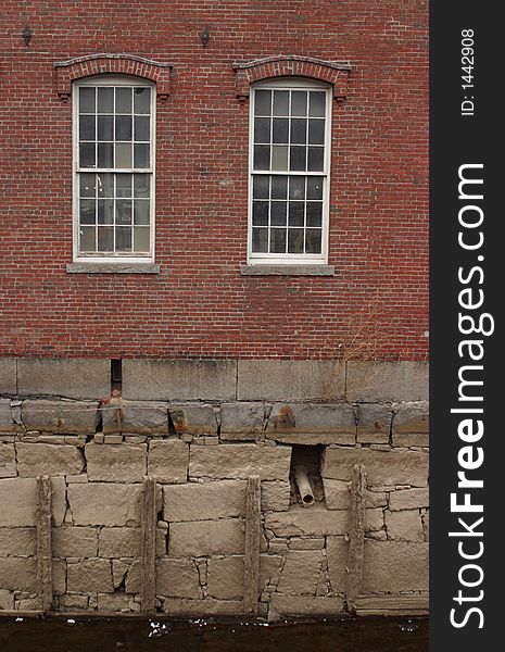 Boott Mills brick wall with canal in the foreground - Lowell National Historical Park