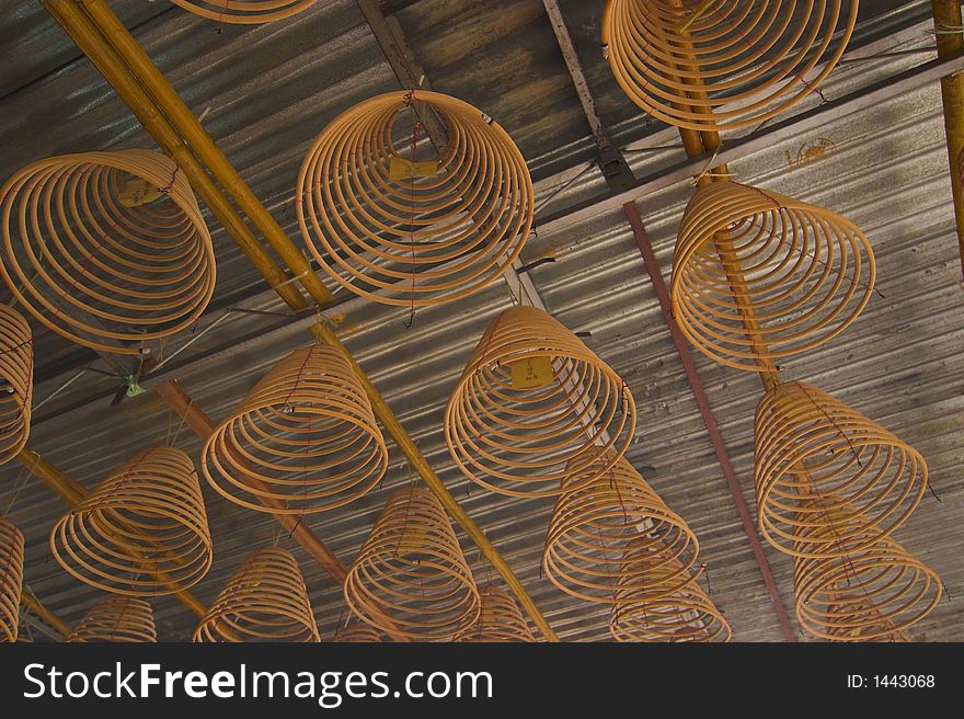 Hanging circular joss-sticks against dark background. Hanging circular joss-sticks against dark background