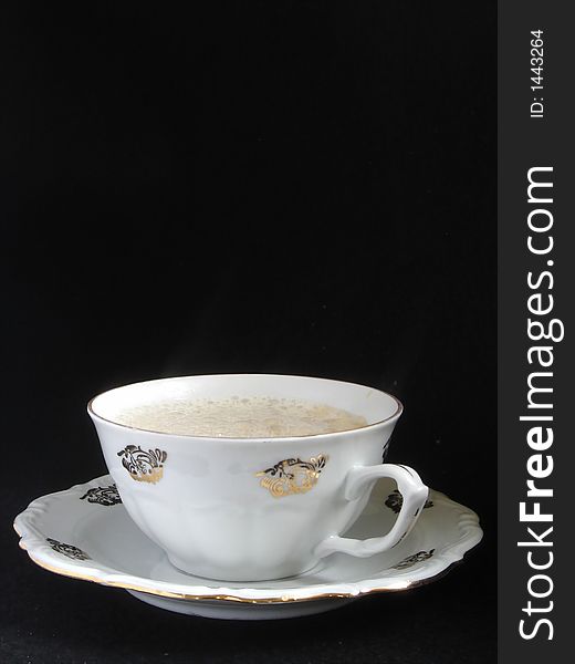 Porcelain cup of cappuccino on black background