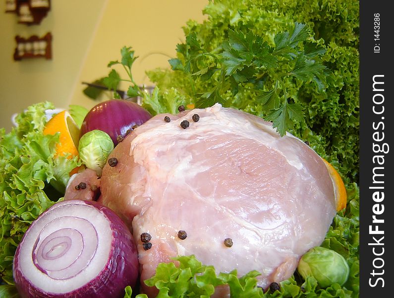 Fresh pork meat garnished with lettuce, purple onion, orange slice, apple and parsley. Fresh pork meat garnished with lettuce, purple onion, orange slice, apple and parsley