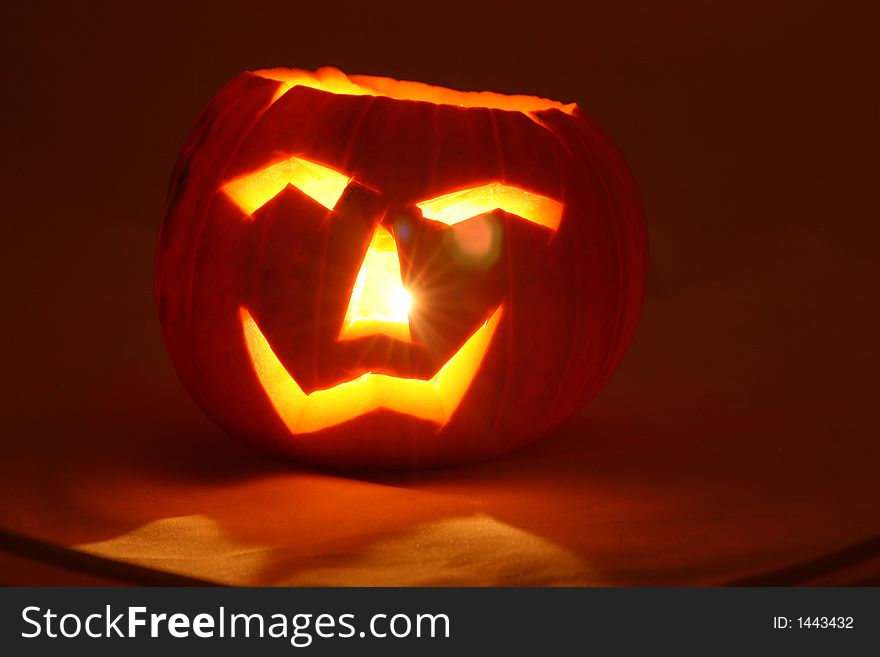 Cutout face in a pumpkin lit for halloween. Cutout face in a pumpkin lit for halloween