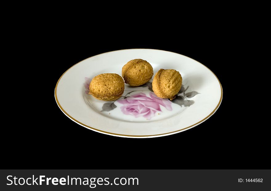 Sweet nutlets on a plate, isolated on black