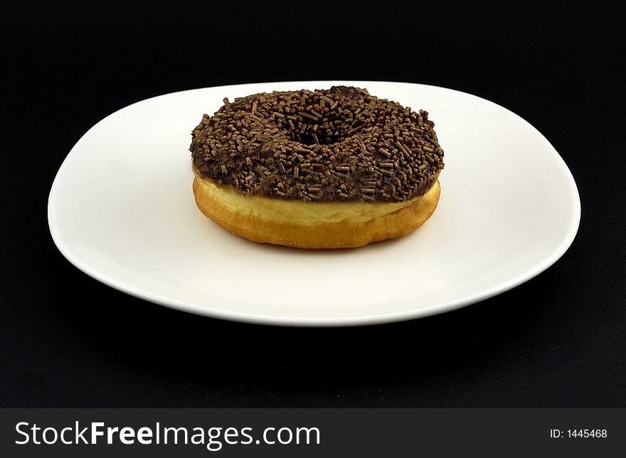 A chocolate doughnut ready to eat. A chocolate doughnut ready to eat