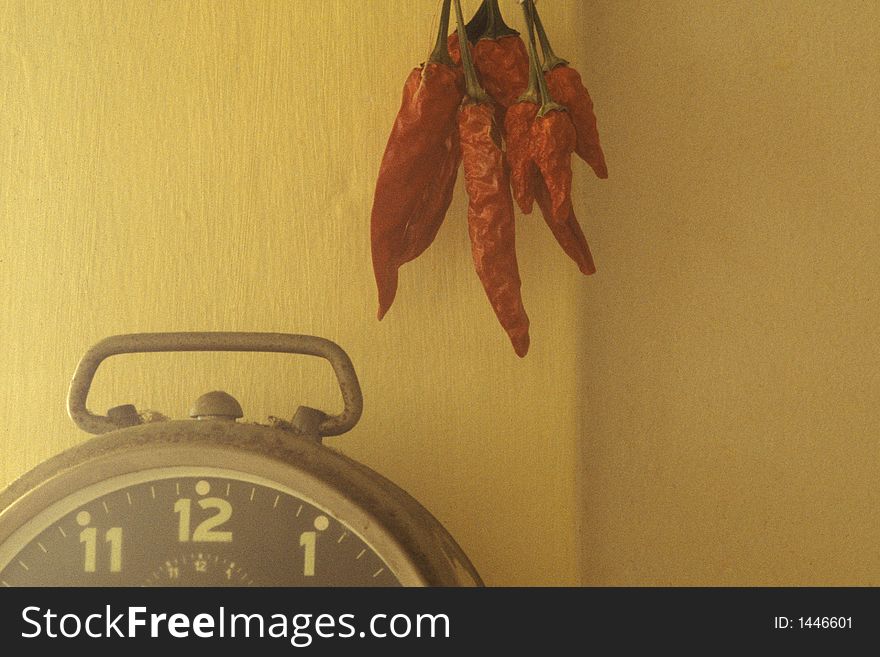 Red peppers aging next to a clock. Red peppers aging next to a clock