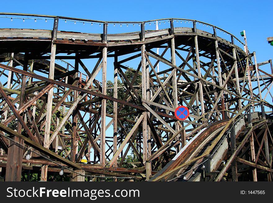 A very old wooden rollercoaster track, bright blue sky in background. A very old wooden rollercoaster track, bright blue sky in background