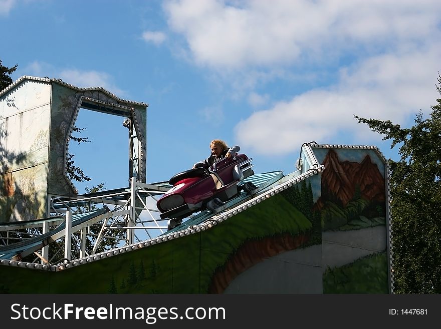 A small boy riding in a rollercoaster having loads of fun. A small boy riding in a rollercoaster having loads of fun