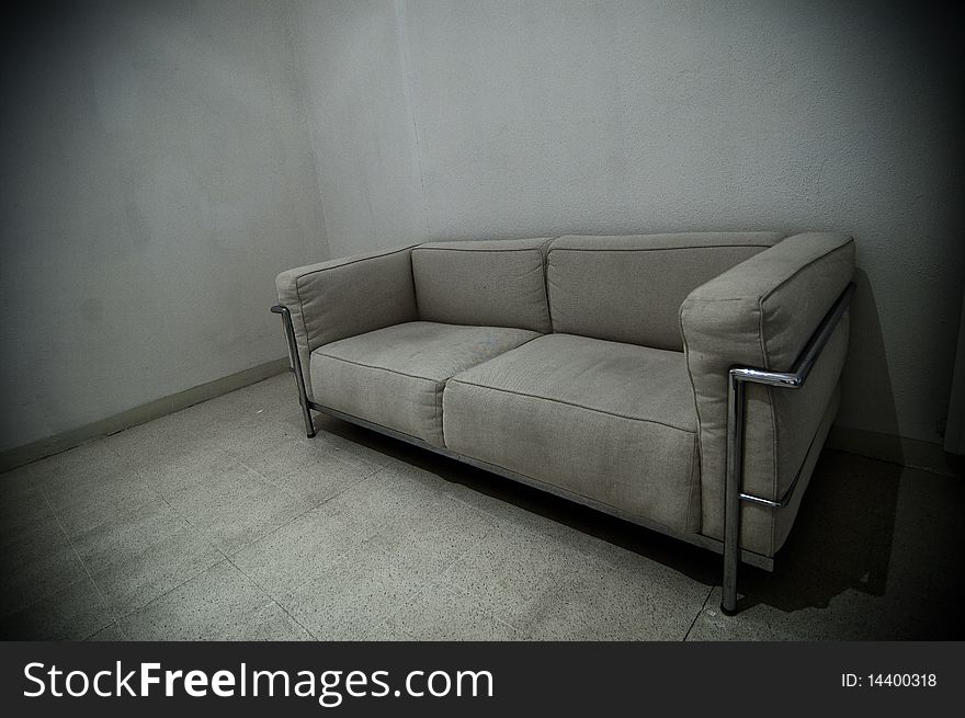 A grey sofa in a grey room. A grey sofa in a grey room