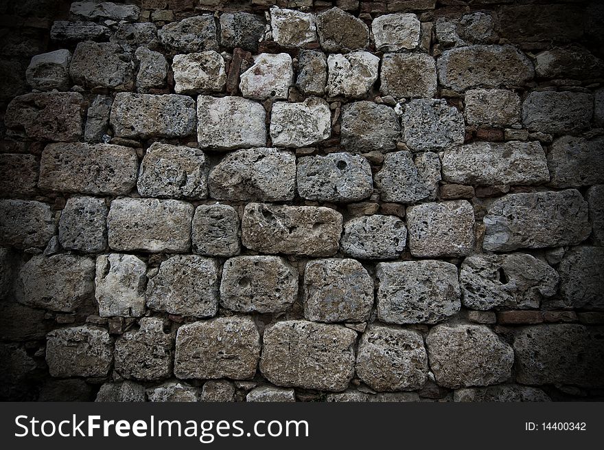 A wall of aged grey stones in line. A wall of aged grey stones in line