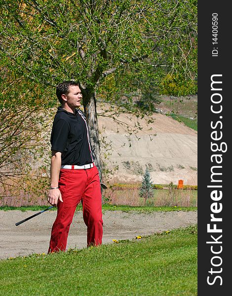 Young male golfer after playing a shot from the bunker