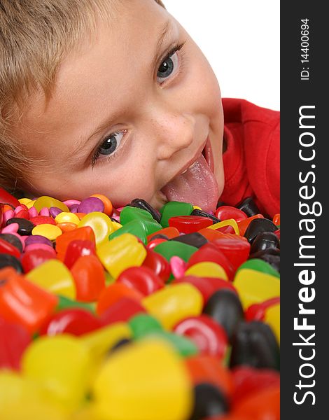 Young boy being with a table full of colorful sweets. Young boy being with a table full of colorful sweets