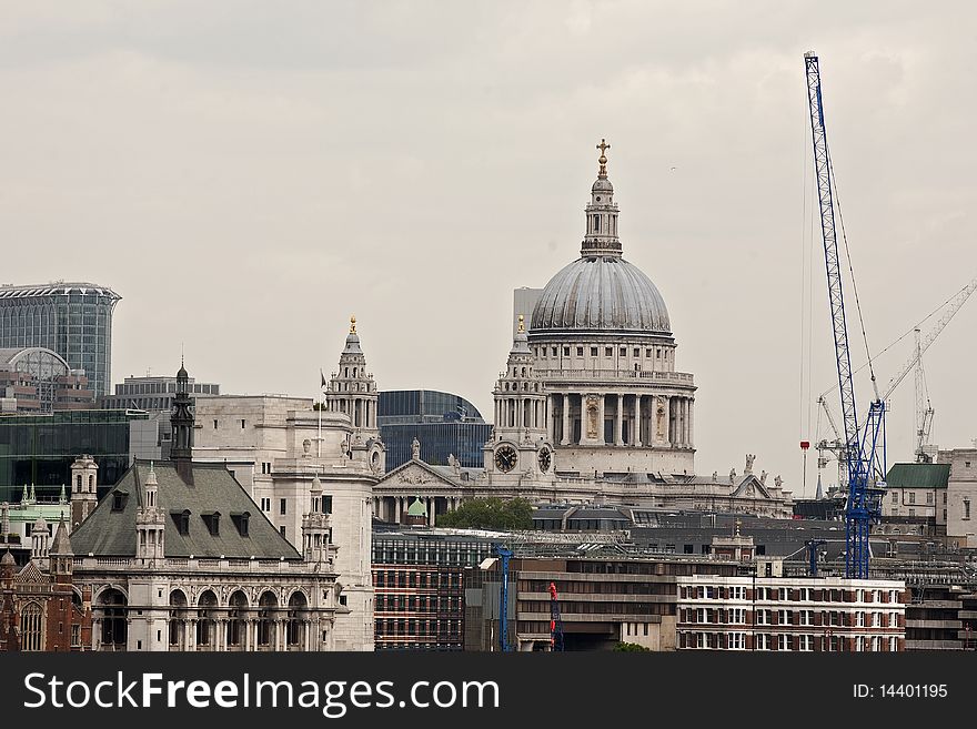 Construction industry and vertical equipments, cloudy sky and Saint Paul Cathdral in background. Construction industry and vertical equipments, cloudy sky and Saint Paul Cathdral in background