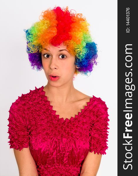 A portrait of a girl in a clown wig, making surprised face. A portrait of a girl in a clown wig, making surprised face