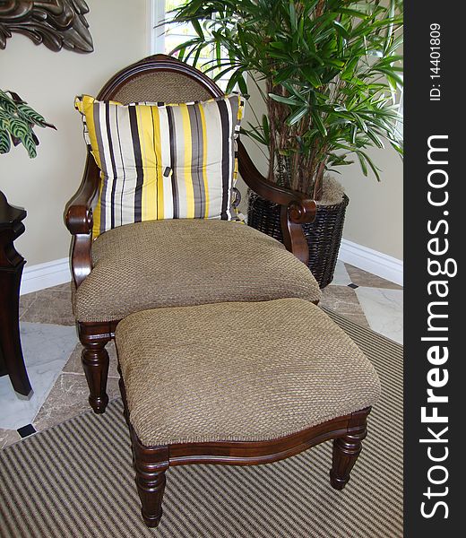 Beautiful chair and foot stool. Chair has yellow and grey pillow.