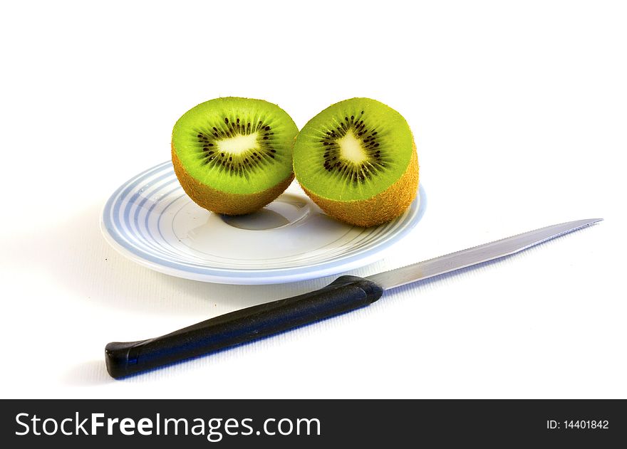 Kiwi sliced on a plate with knife
