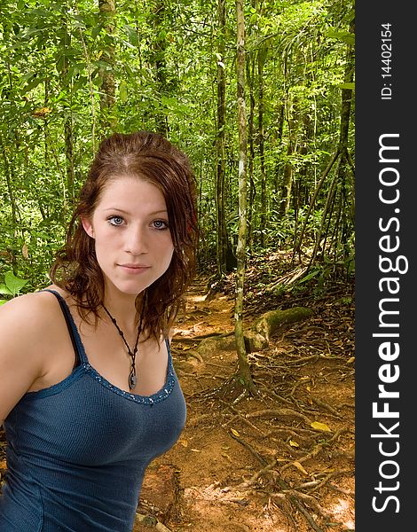 Pretty young woman in blue hiking along a forest trail. Pretty young woman in blue hiking along a forest trail.