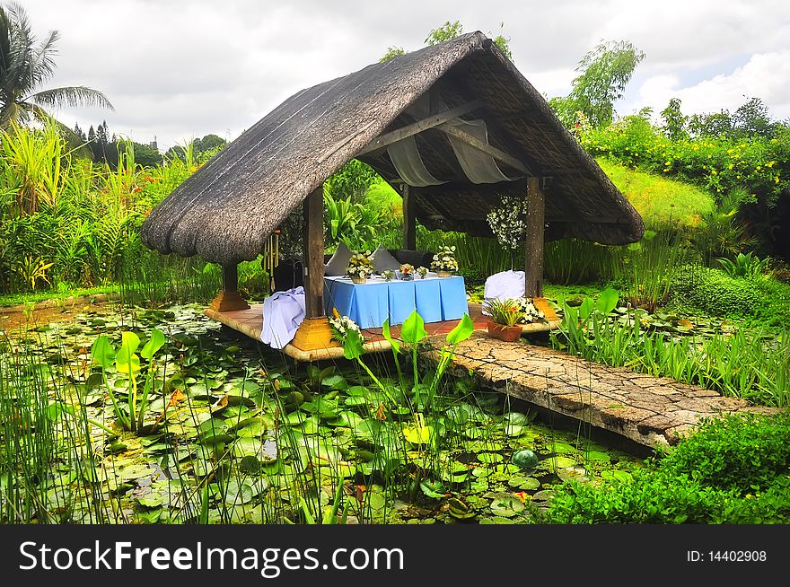 Nipa hut in the middle of a pond with lily