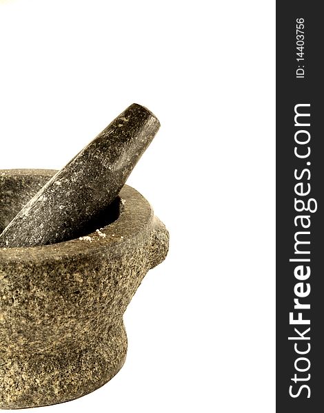 A heavy stone granite Mortar and Pestle with sprinklings of ginger powder against a white background. A heavy stone granite Mortar and Pestle with sprinklings of ginger powder against a white background.