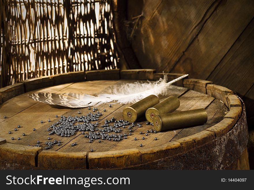 Shotgun shells and shot on wood background