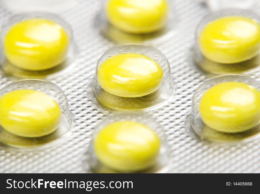 Macro shot of yellow pills` set isolated on white backround