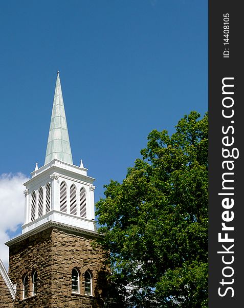 A white church steeple against a blue sky