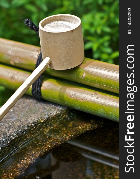 A cup for a bamboo fountain used for cleaning and purification in a Shinto temple. A cup for a bamboo fountain used for cleaning and purification in a Shinto temple.