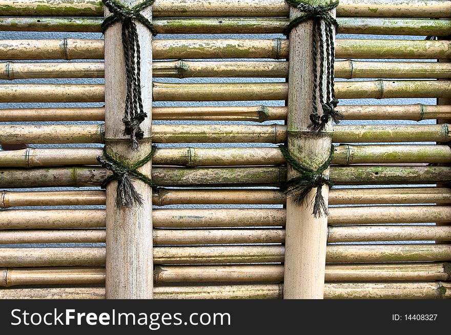 A light colored bamboo fence in a Shinto temple