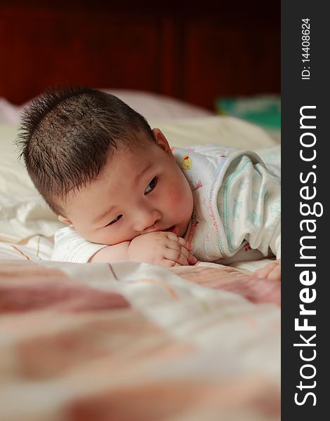 Lovely Chinese baby is playing toy in the bed