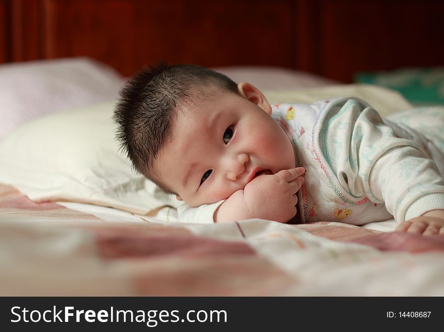 Lovely Chinese baby is playing in the bed