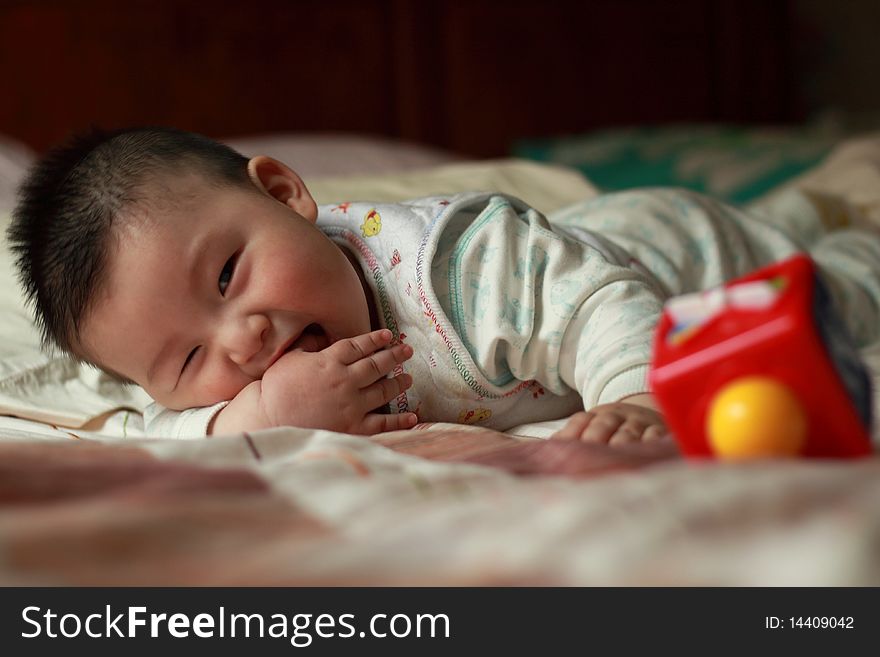 Lovely Chinese baby is playing in the bed