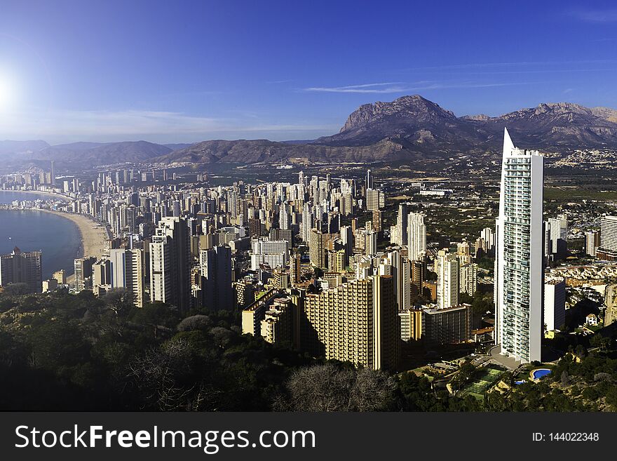 Top view of Benidorm Spain with skyscrapers and mountains and coastline on a sunny day.
