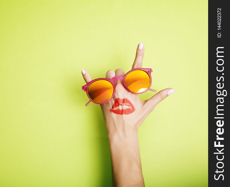 Woman hand holding sunglasses on bright background, cosmetic summer vacation concept close up