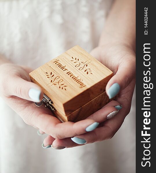 The bride is holding a box with wedding rings.