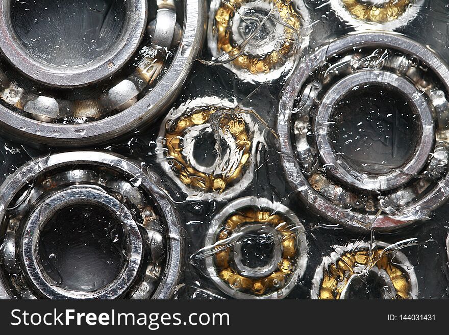 Strike concept. Closeup set of ball bearings under frozen water. Strike concept. Closeup set of ball bearings under frozen water