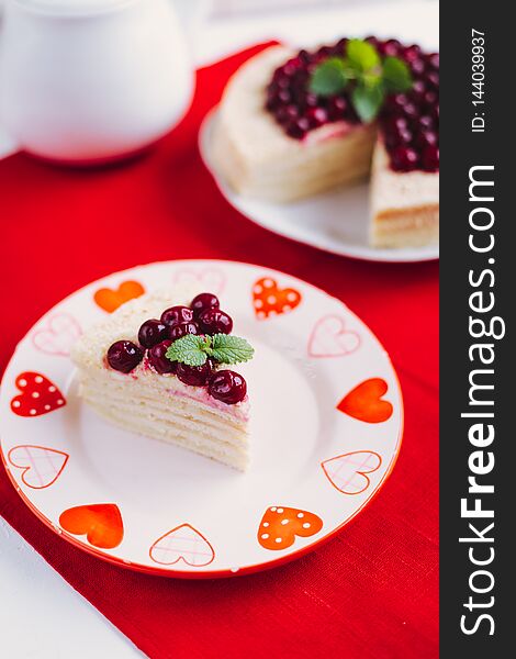 Homemade cherry cake with mint on a red blurred background