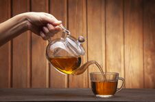 Woman Hand Poured Cup Of Tea On A Wooden Table From A Teapot Stock Image