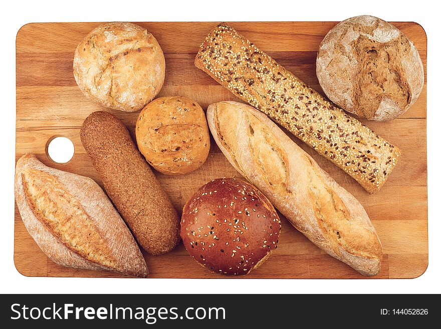 Top view of different types of bread on wooden kitchen cutting board isolated on white background