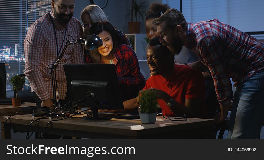 Medium long shot of men reaching success and celebrating with coworkers. Medium long shot of men reaching success and celebrating with coworkers