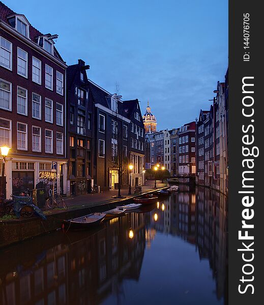 Amsterdam canal Amstel with typical dutch houses and houseboat from the boat in the evening, Holland, Netherlands